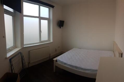 A cozy single bedroom featuring a neatly made b...