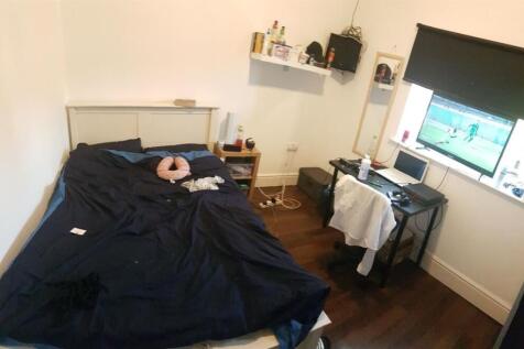 A cozy bedroom with a neatly made bed, a study ...