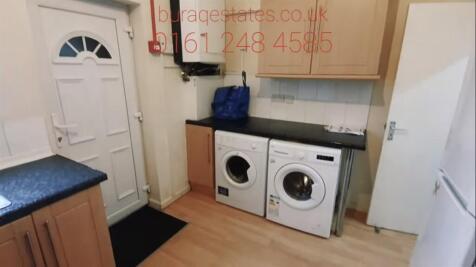 A compact laundry area with washing machines po...