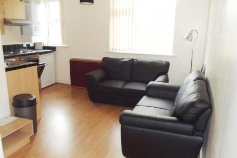 A modern living room featuring two black leathe...