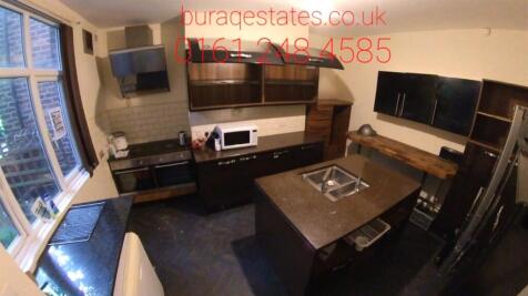 Modern kitchen featuring dark cabinetry, a cent...