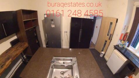 A modern kitchen with dark cabinetry, a stainle...