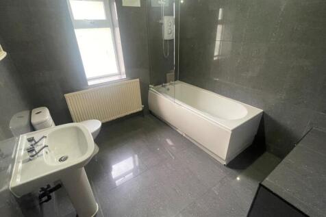 A spacious and modern bathroom with a large bat...