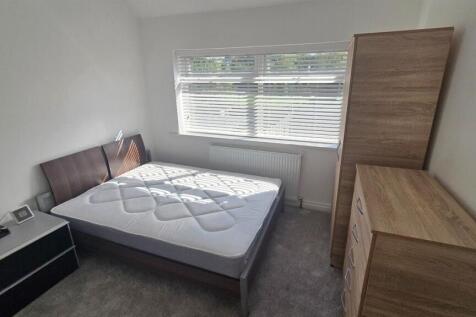 A well-lit, neatly maintained double bedroom wi...