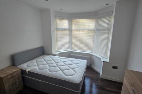 A bright and tidy bedroom featuring a comfortab...