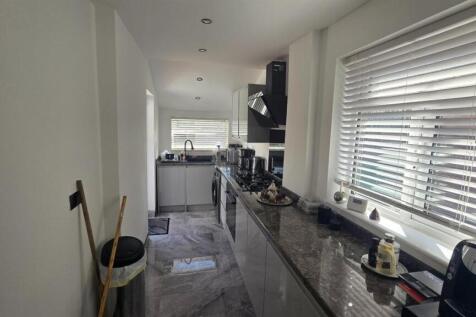 A modern and well-lit kitchen with ample worksp...