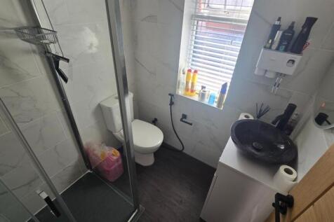 A modern and tidy bathroom with a shower cubicl...