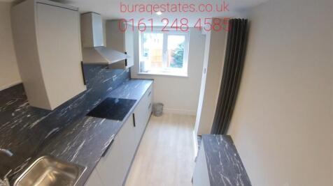 A bright and modern kitchen area featuring a sl...