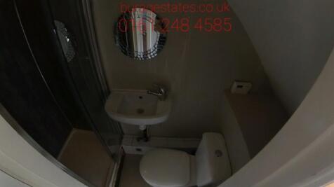 A tidy bathroom with a WC and sink, featuring a...