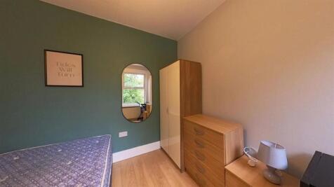 A cozy bedroom featuring a single bed with colo...