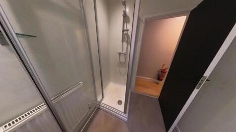 A clean and modern shower room with glass doors...