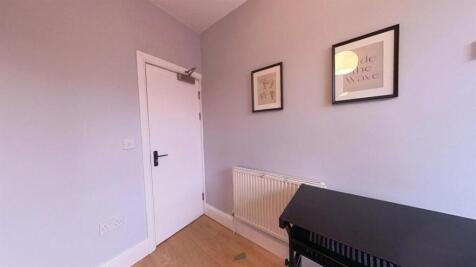 Neat, simply furnished bedroom with pale walls,...