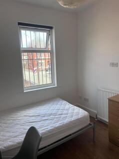 A bright and tidy small bedroom featuring a sin...