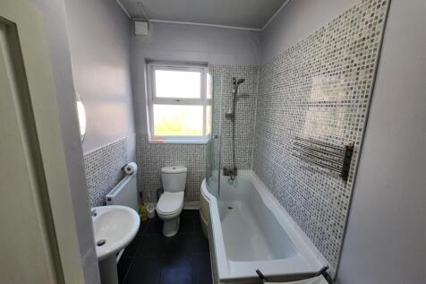 A modern bathroom with a large bathtub, a windo...