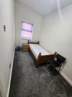 A simple, tidy single bedroom featuring a woode...