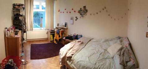 A cozy bedroom featuring a single bed with a be...