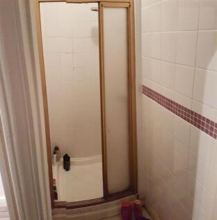 A clean and functional bathroom with tiled wall...