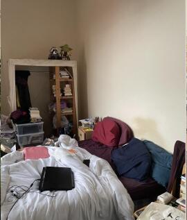 A cozy bedroom with a bed, featuring visible cl...