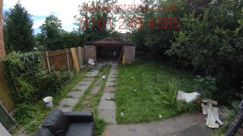 A private garden featuring a green lawn, mature...