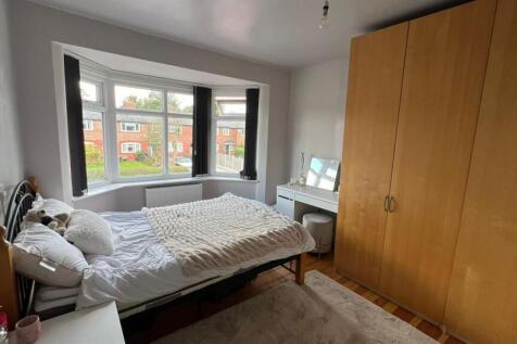 A cozy single bedroom featuring a bed, a wardro...