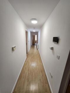 Bright, well-maintained interior hallway with l...