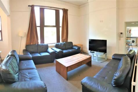 A spacious, well-lit living room featuring comf...