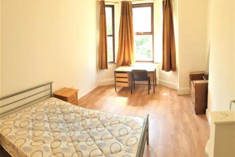 A well-lit bedroom with a large window and simp...