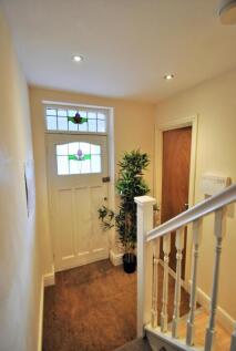 A bright and tidy hallway featuring a decorativ...