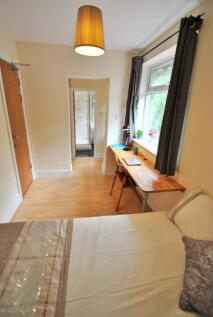 A cozy single bedroom featuring a neatly made b...