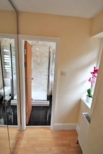 Bright and tidy hallway with light wooden floor...