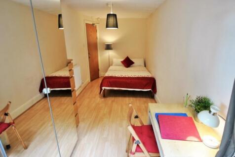 A neat and comfortable single bedroom featuring...