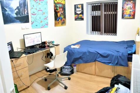 A cozy single bedroom featuring a neatly made b...