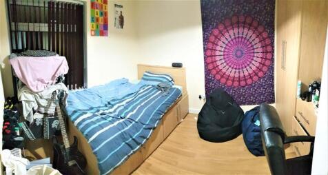 A cozy single bedroom featuring a bed with a bl...