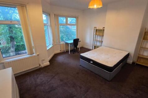 Bright double bedroom with a large bay window o...