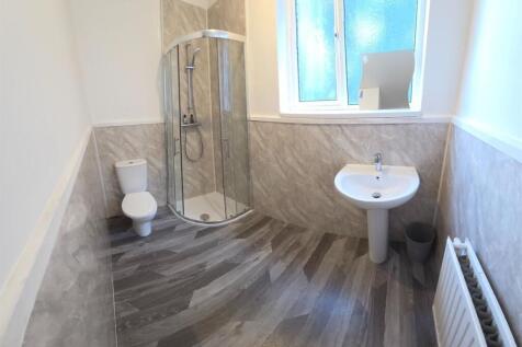 Bright, modern bathroom with a corner glass sho...