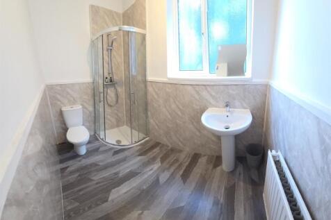 Bright, modern bathroom with corner glass showe...