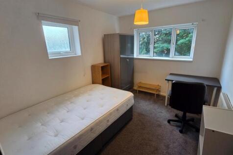 Bright, simply furnished bedroom with a comfort...