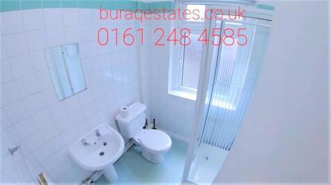 Bright, tiled bathroom with a pedestal sink, to...