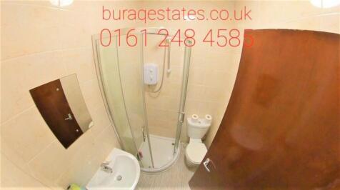 A compact, clean bathroom featuring a shower en...