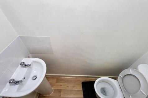A clean and simple single toilet with a white s...