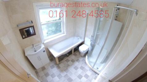 Bright and clean bathroom suite featuring a cur...