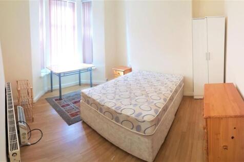 A tidy bedroom featuring a single bed, a wardro...