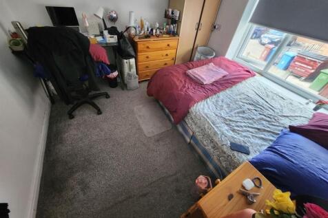 A cozy bedroom featuring a double bed with purp...