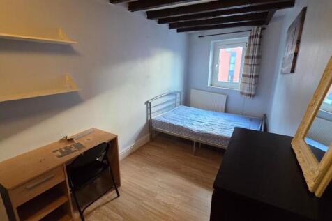 A cozy single bedroom featuring a bed positione...