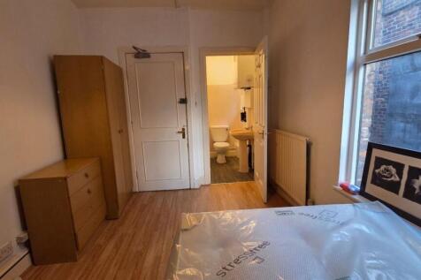 A bright and inviting bedroom featuring a comfo...