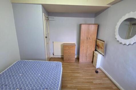 A tidy bedroom featuring a bed and minimal furn...