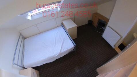 A tidy single bedroom featuring a white bed wit...