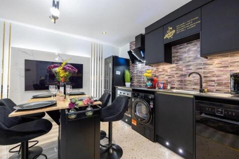 Modern open-plan kitchen with sleek black cabin...