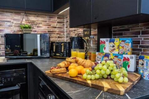 Modern galley-style kitchen with dark cabinetry...
