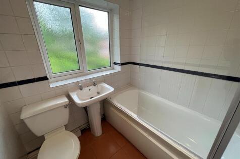 A spacious bathroom featuring a large bathtub a...